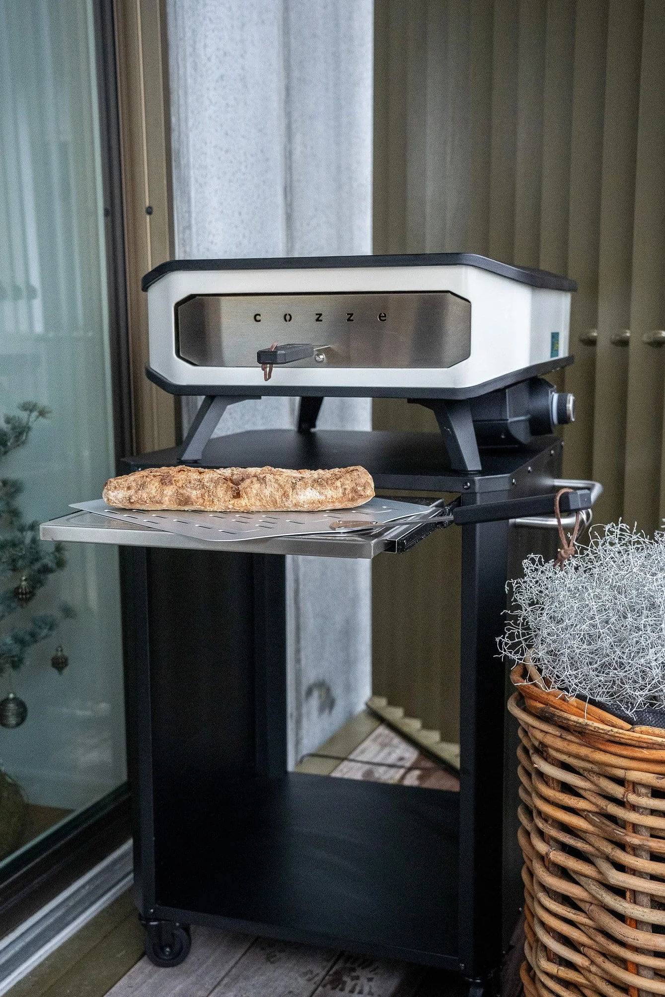 Cozze® | Mesa Exterior con Tabla de Corte Extensible | para hornos hasta 60 cm | Asas Laterales con 6 Ganchos de Acero Inoxidable | Ruedas de Goma Ø75 mm | Espacio para bombona | Acero Lacado Negro